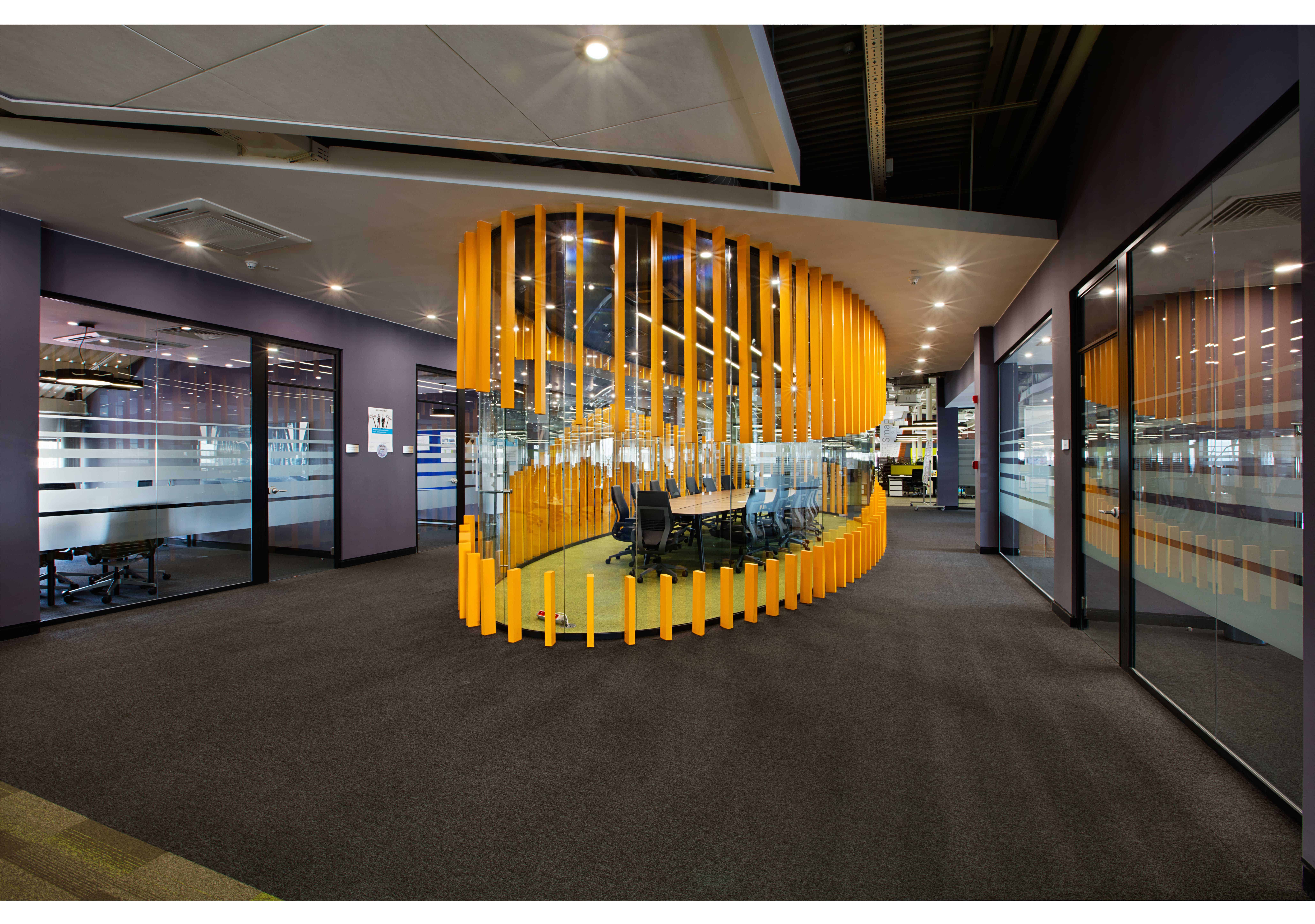 Modern office conference room with innovative wooden and glass design elements, featuring a creative circular wooden structure surrounding a meeting table.