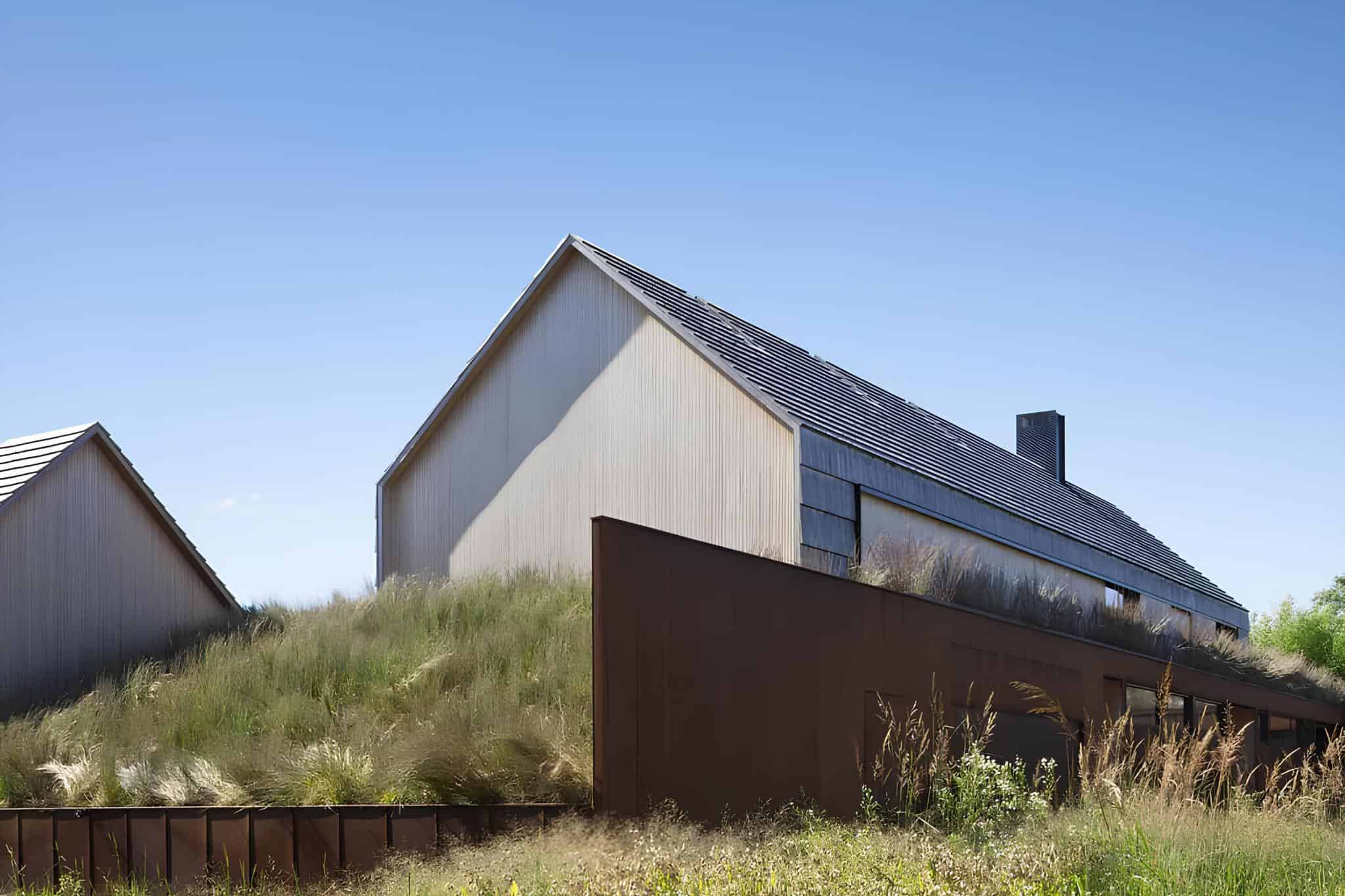 Pierson's Way Residence Exterior Lawn View Modern residence with pitched roofs and expansive lawn in East Hampton.