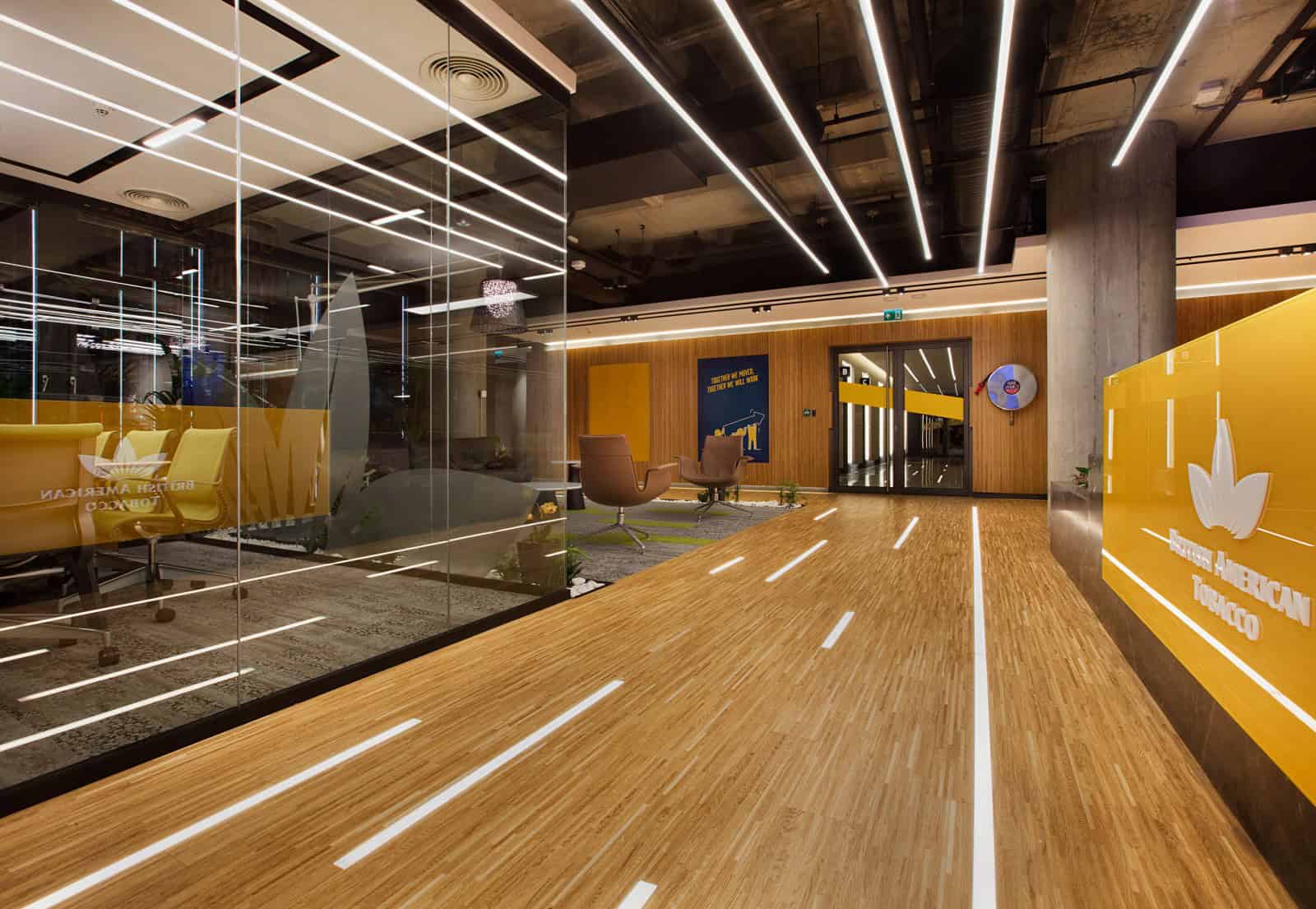 Modern office interior with contemporary lighting, wooden accents, and glass partitions, showcasing innovative architectural design for corporate spaces.
