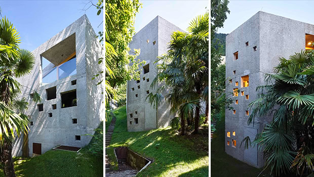 Modern concrete house with geometric windows, surrounded by lush greenery, showcasing contemporary architecture and innovative design.