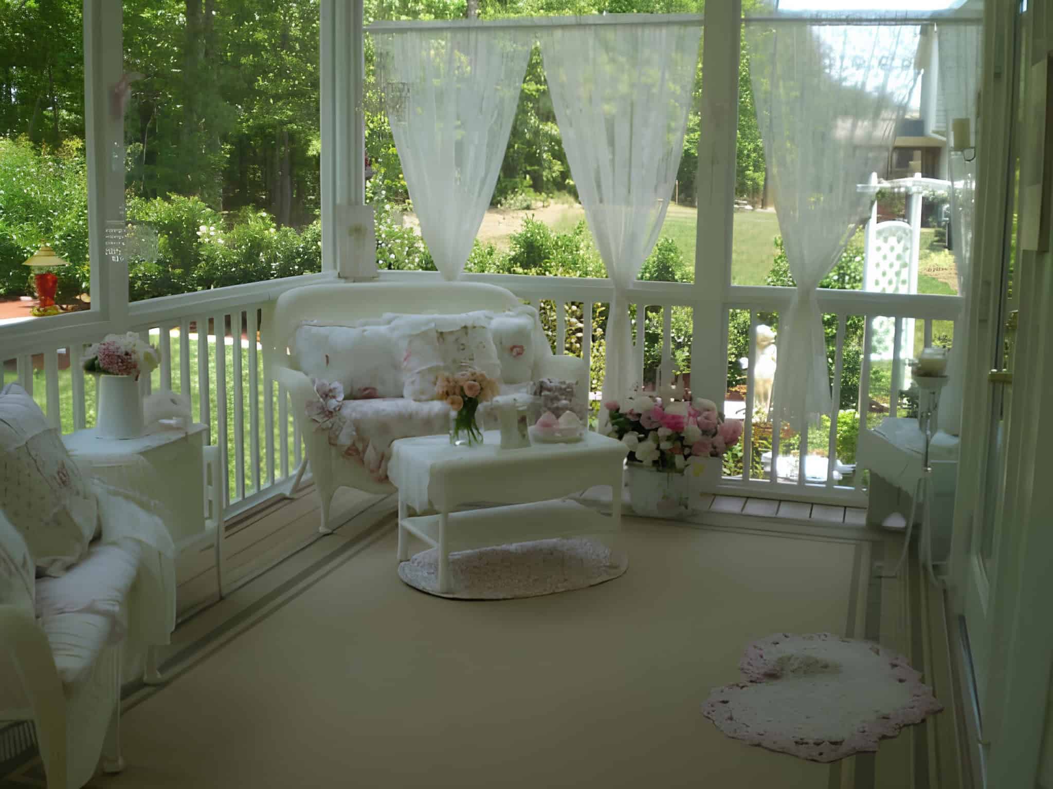 White shabby chic porch with floral cushions and sheer curtains