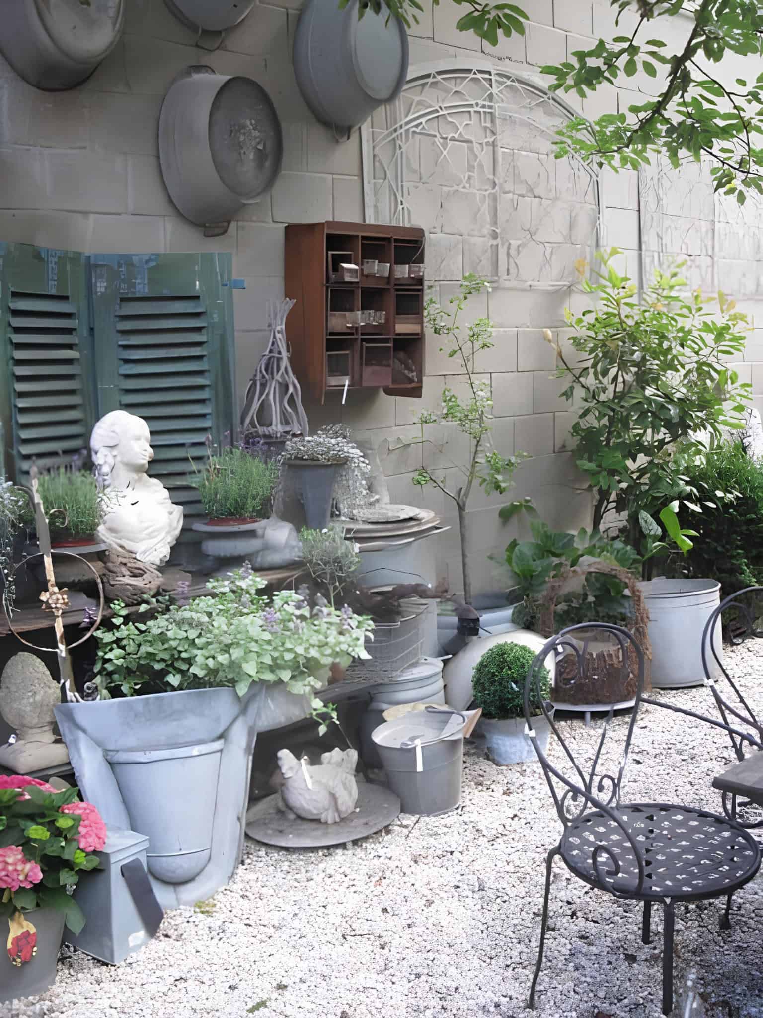 Vintage garden corner filled with planters, busts, and decor