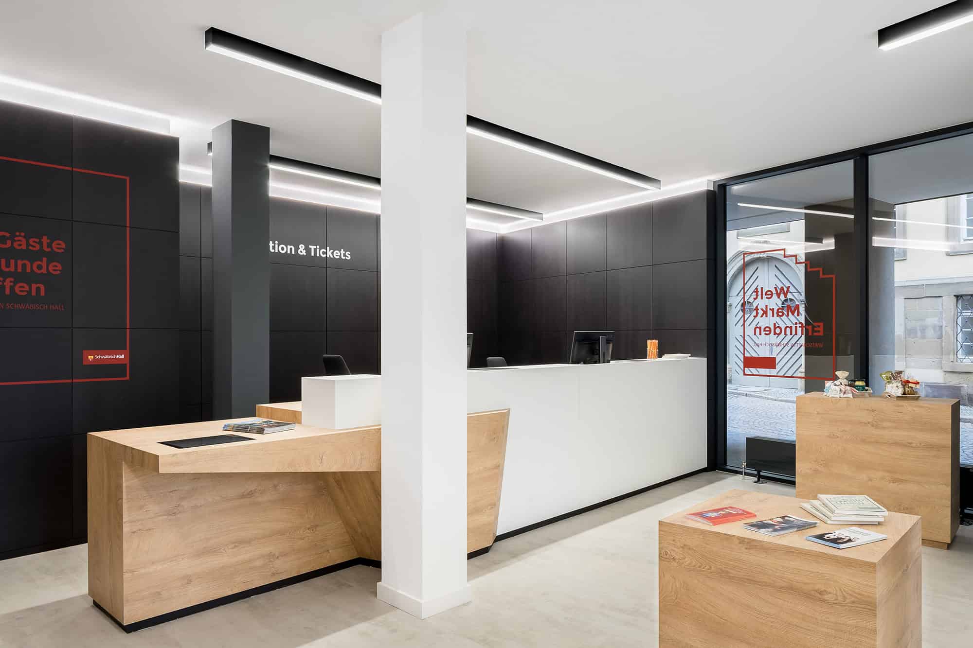 Sleek modern interior of a reception area with black and white walls, wooden accents, and contemporary lighting, showcasing innovative architecture and interior design elements.