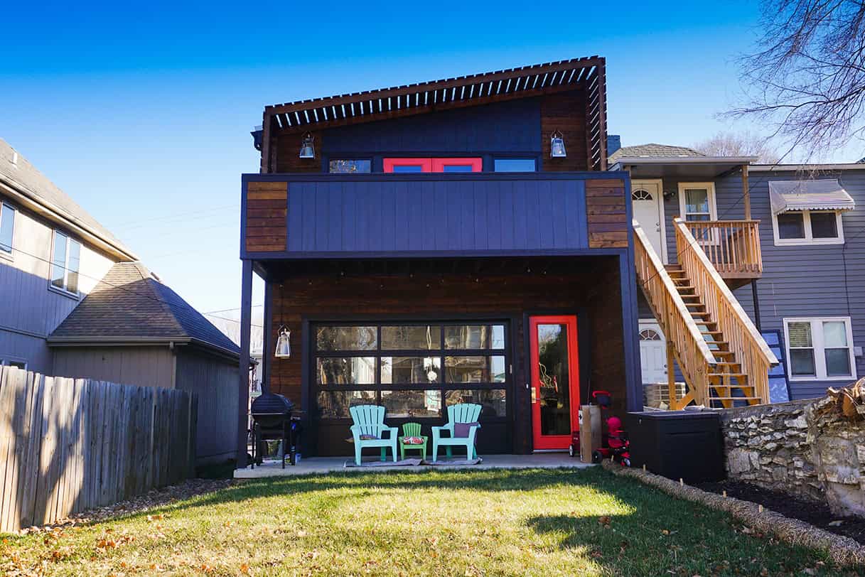 Modern custom home with a striking architectural design featuring bold color accents and contemporary outdoor patio furniture, exemplifying innovative architecture art and stylish residential design.