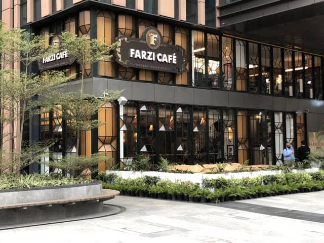 Farzi Café exterior view showcasing modern architectural design with glass panels and stylish signage, perfect for contemporary restaurant architecture enthusiasts.
