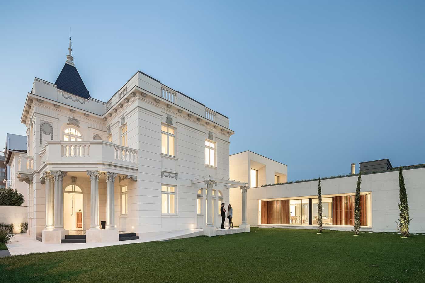 Luxurious white classical mansion with ornate architectural details, columns, and spacious lawn, blending historic elegance with modern design elements.