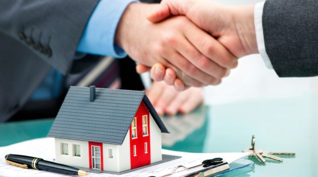 Estate agent shaking hands with customer after contract signature
