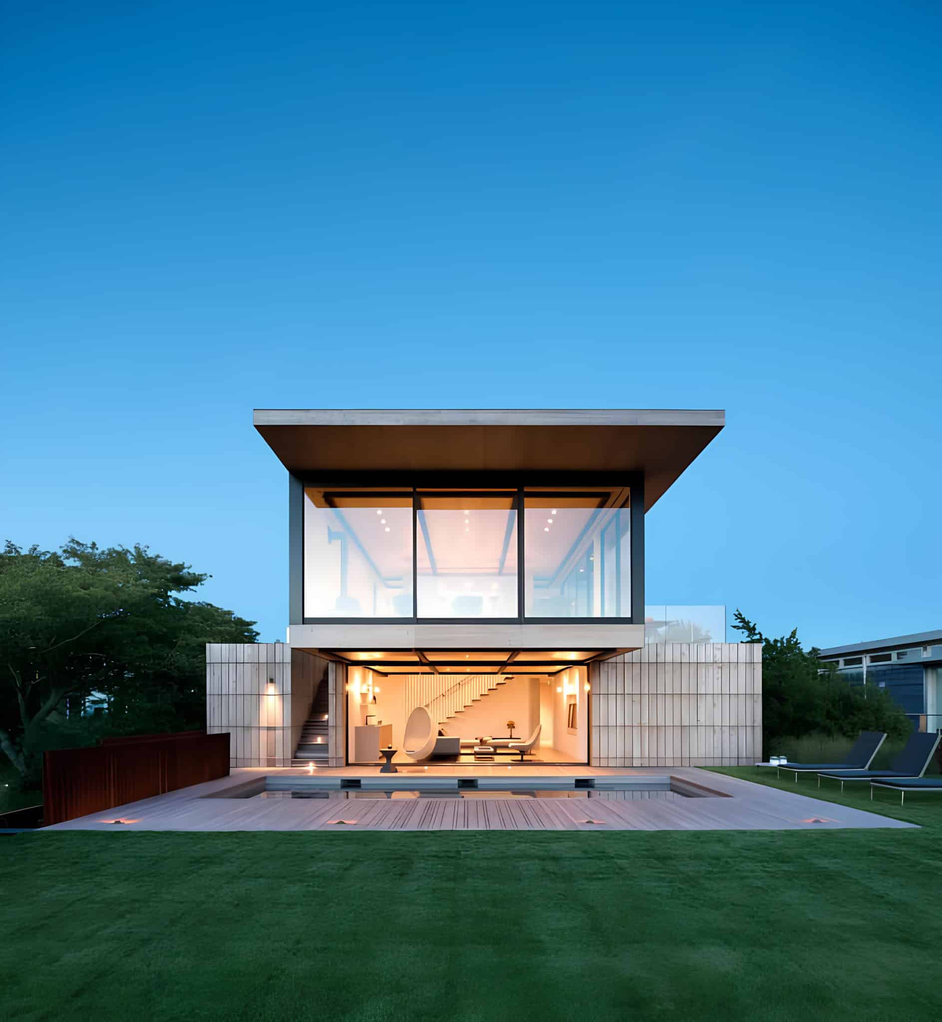 Modern minimalist house with large glass windows, outdoor pool, and contemporary design, showcasing sleek architecture and stylish outdoor living space.