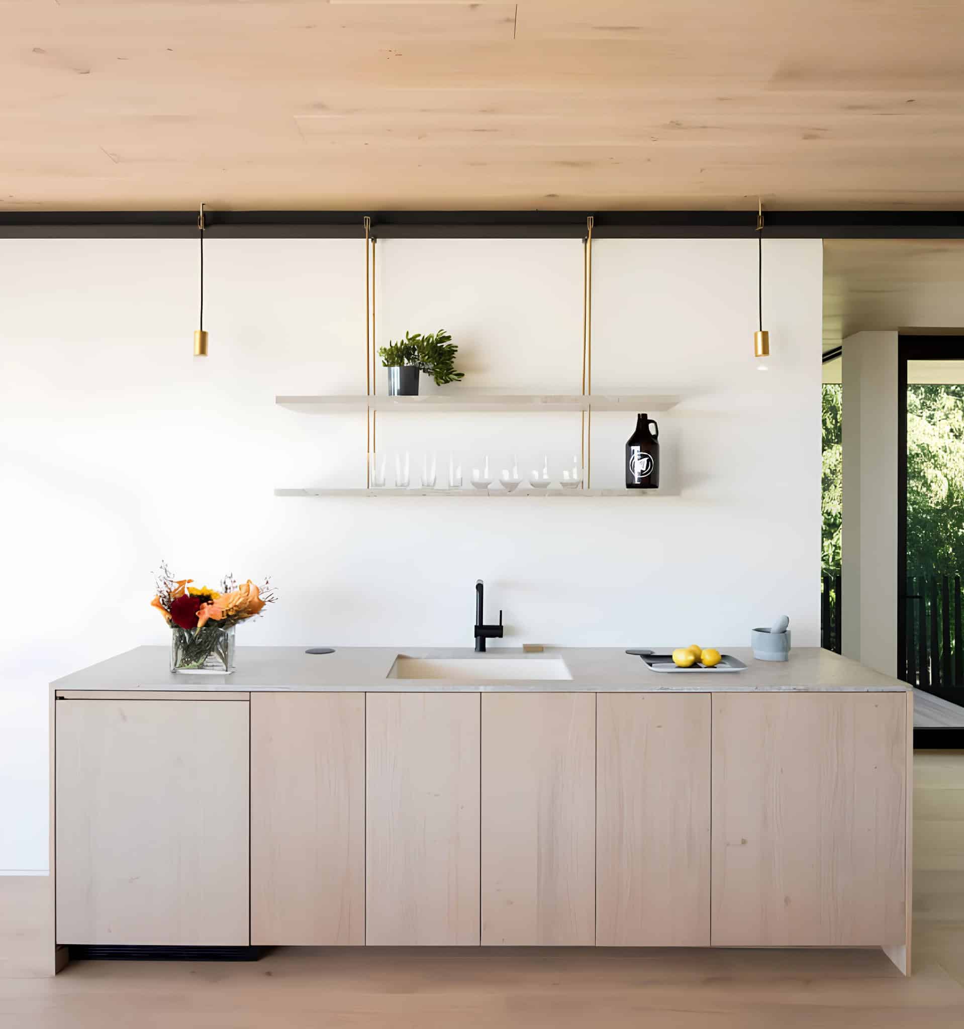 Atlantic House Minimalist Kitchen with Floating Shelves Minimalist kitchen island with suspended shelving and black faucet in Atlantic House.