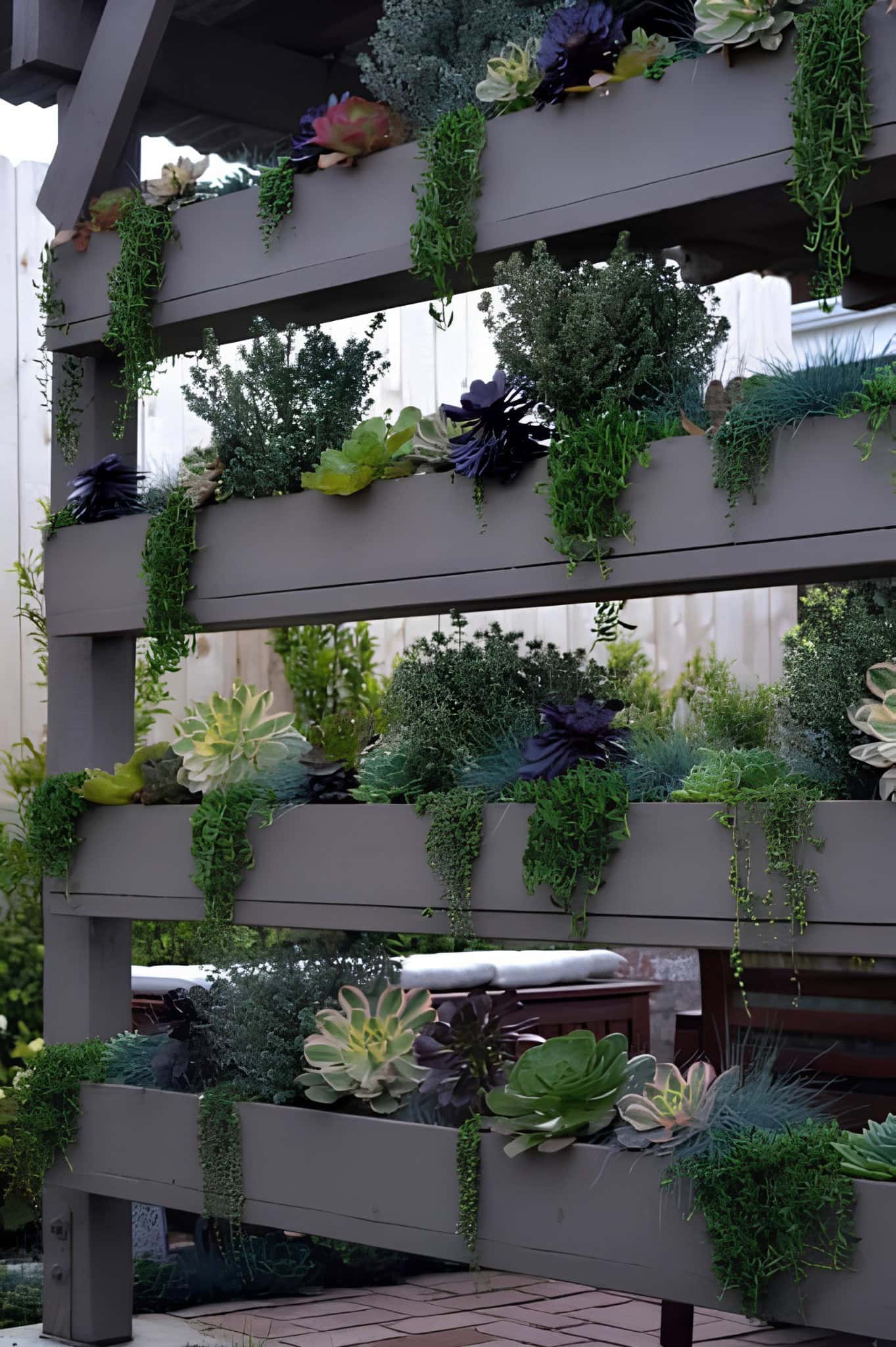 Outdoor vertical garden with cascading succulents in wooden tiers
