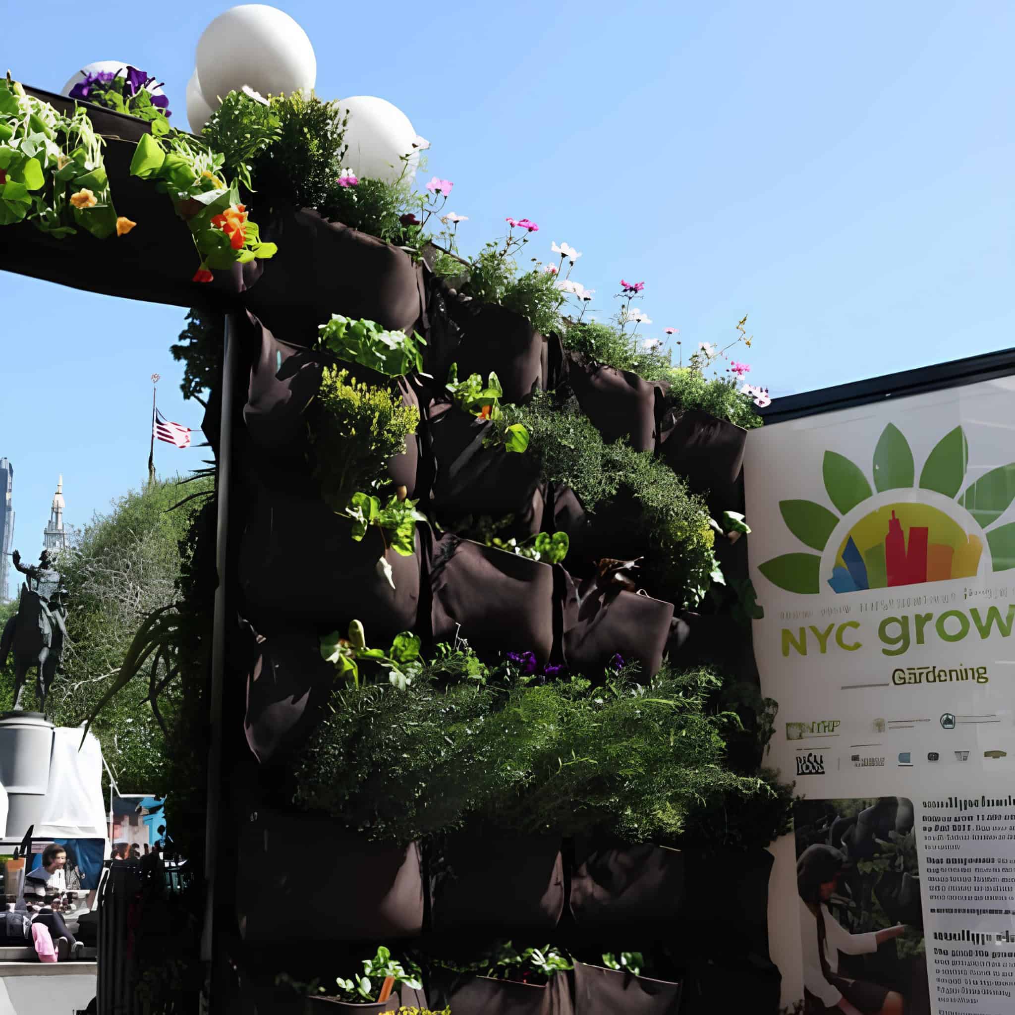 NYC outdoor vertical wall garden with black grow bags and flowering plants