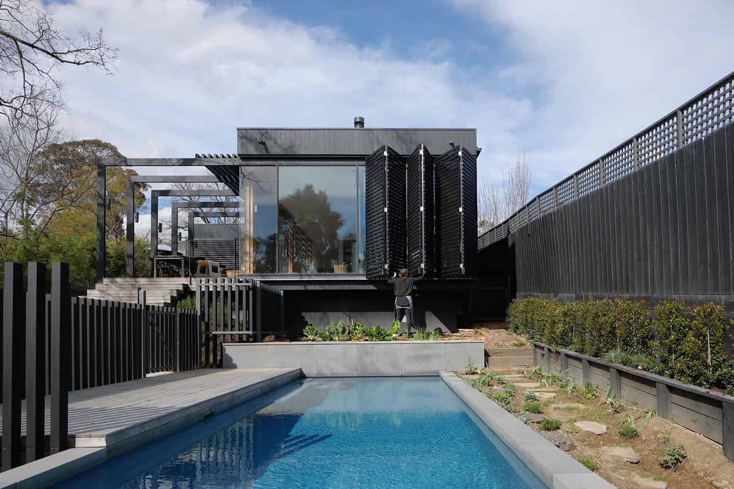 Contemporary black modern house with glass walls, sleek design, and outdoor pool showcasing innovative architecture and modern home design elements.