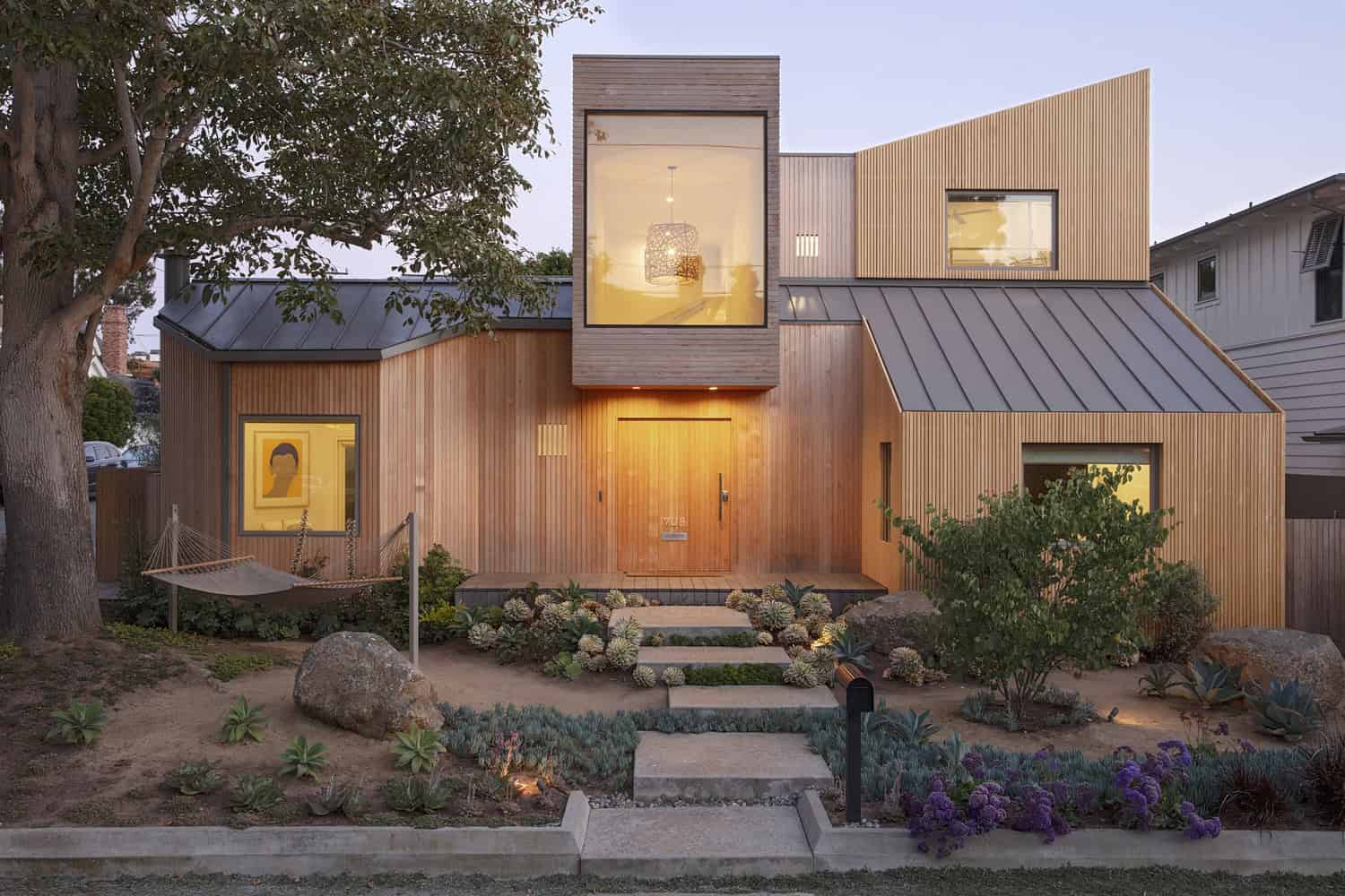 Modern wooden architectural house with contemporary design, large windows, and lush landscaped garden, showcasing innovative architecture and stylish exterior details.