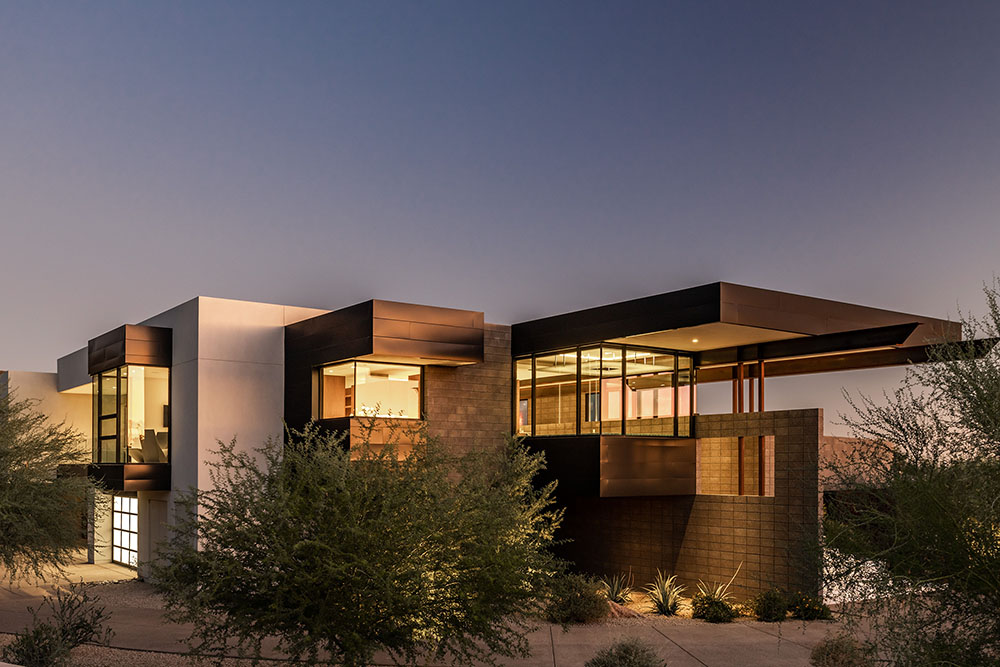 Luxurious modern desert home with sleek architecture, large glass windows, and contemporary design elements. Perfect example of innovative architecture art designs in desert landscapes.