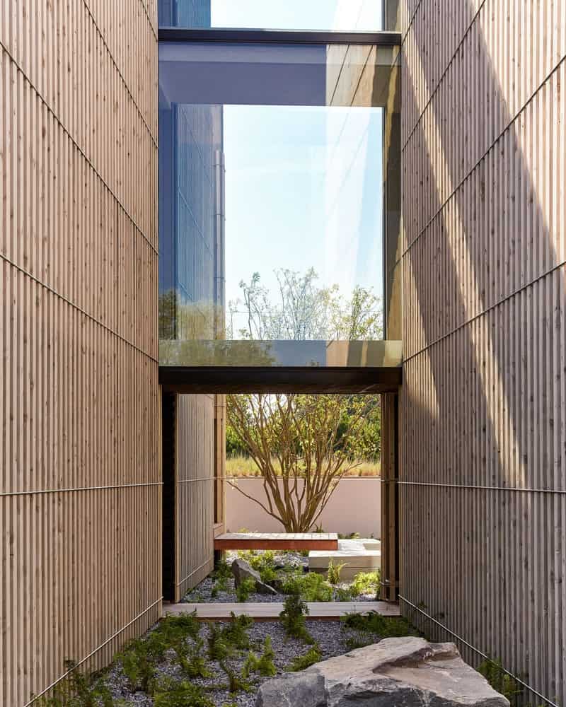 Kiht’han House Glass Bridge Courtyard View Glass bridge connecting volumes of Kiht’han House overlooking a minimalist courtyard.