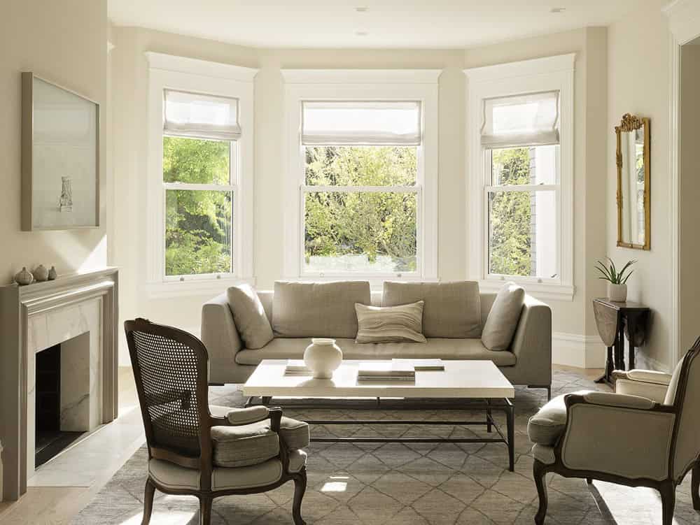 Elegant living room with large bay windows and classic furnishings, featuring a cozy neutral color palette, sophisticated decor, and natural light, perfect for modern interior design enthusiasts.