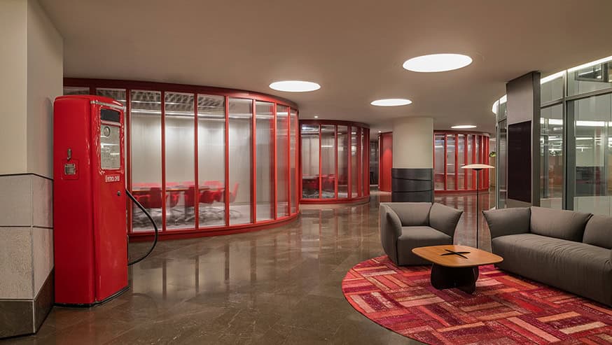 Red vintage payphone and modern lounge area in contemporary office interior.