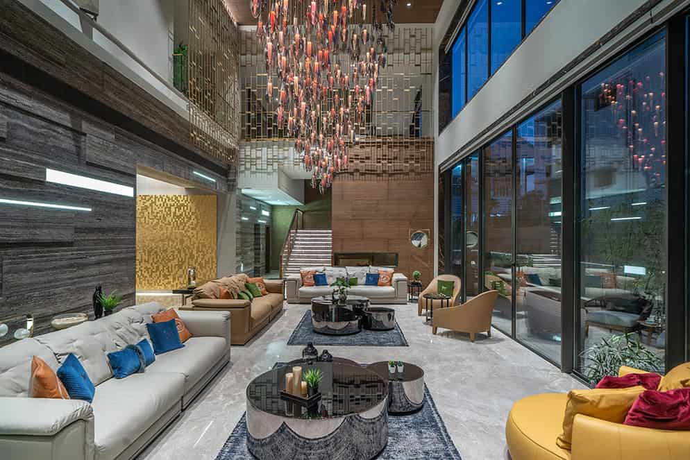 Luxurious hotel lobby with modern interior design, elegant seating, contemporary lighting fixture, and expansive glass walls offering city views, perfect for upscale architecture and interior design inspiration.