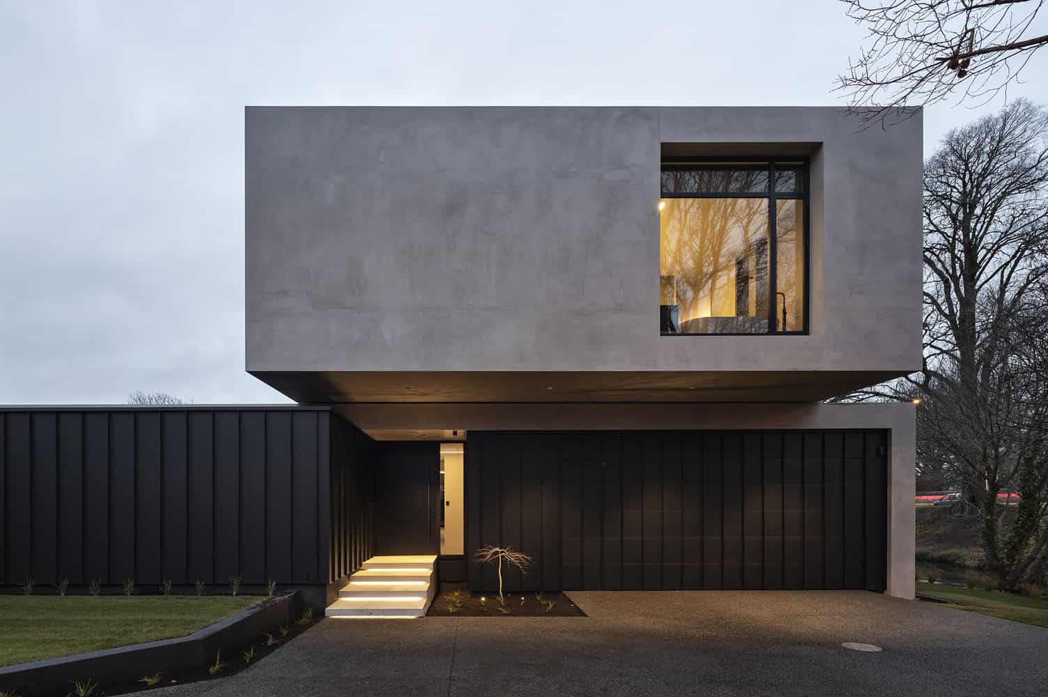 Contemporary modern house with minimalist concrete and black facade, showcasing sleek architectural design, innovative facade, and stylish lighting for urban residential architecture.