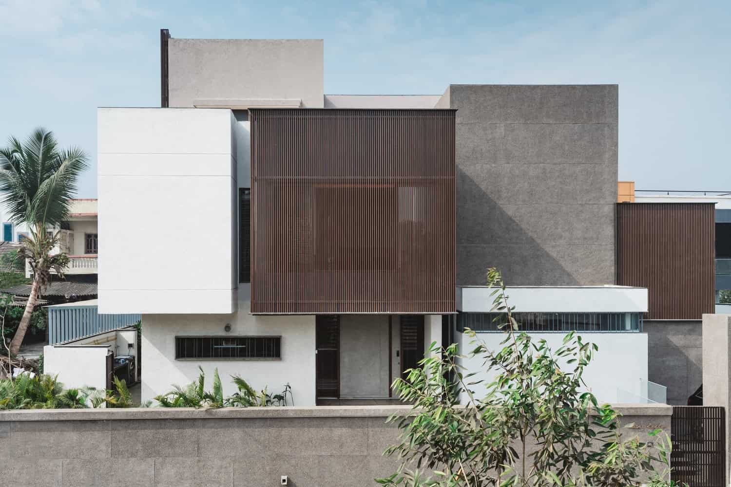 Contemporary modern house with sleek geometric design, wooden slat accents, and minimalist architecture for stylish urban living.