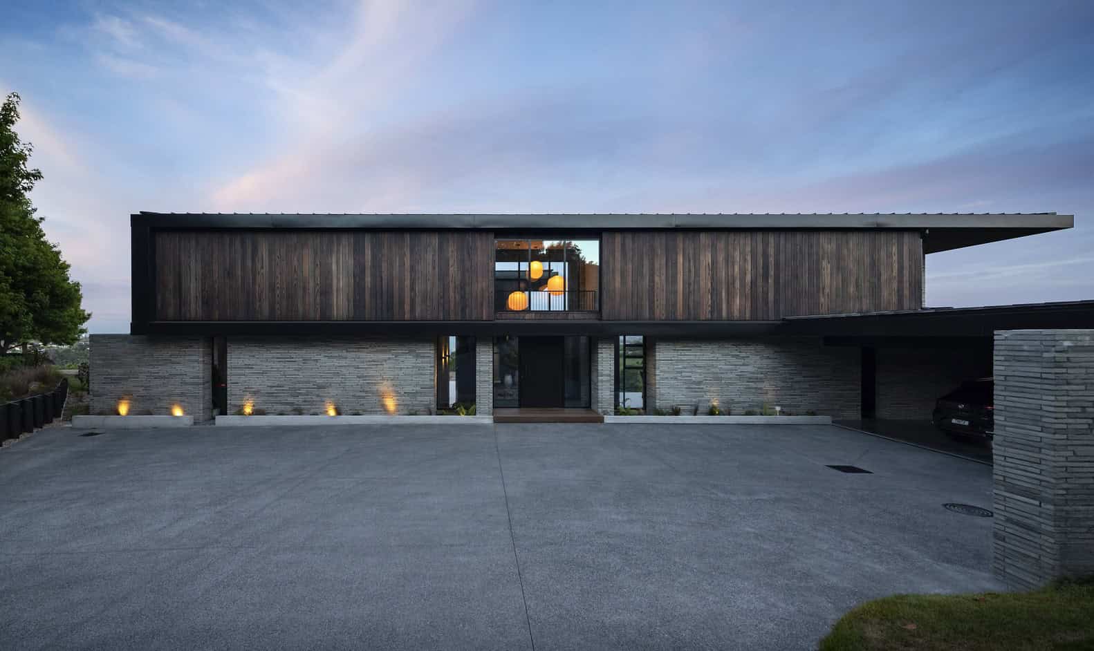 Contemporary modern house featuring wood and brick exterior, minimalist design, and sleek landscaping, showcasing innovative architecture and sustainable building materials.