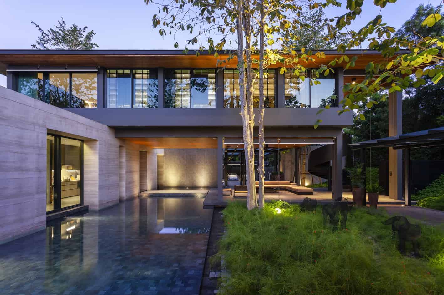 Contemporary modern house with large glass windows, minimalist design, and lush outdoor landscaping, showcasing innovative architecture and stylish outdoor living spaces.
