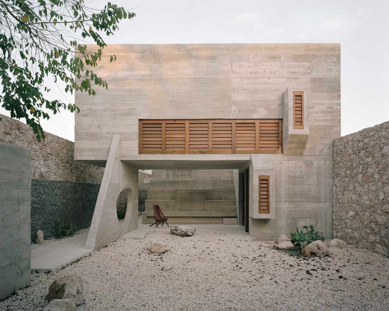 Contemporary minimalist concrete house with wooden accents, modern architecture design, clean lines, and natural landscaping, showcasing innovative residential architecture.