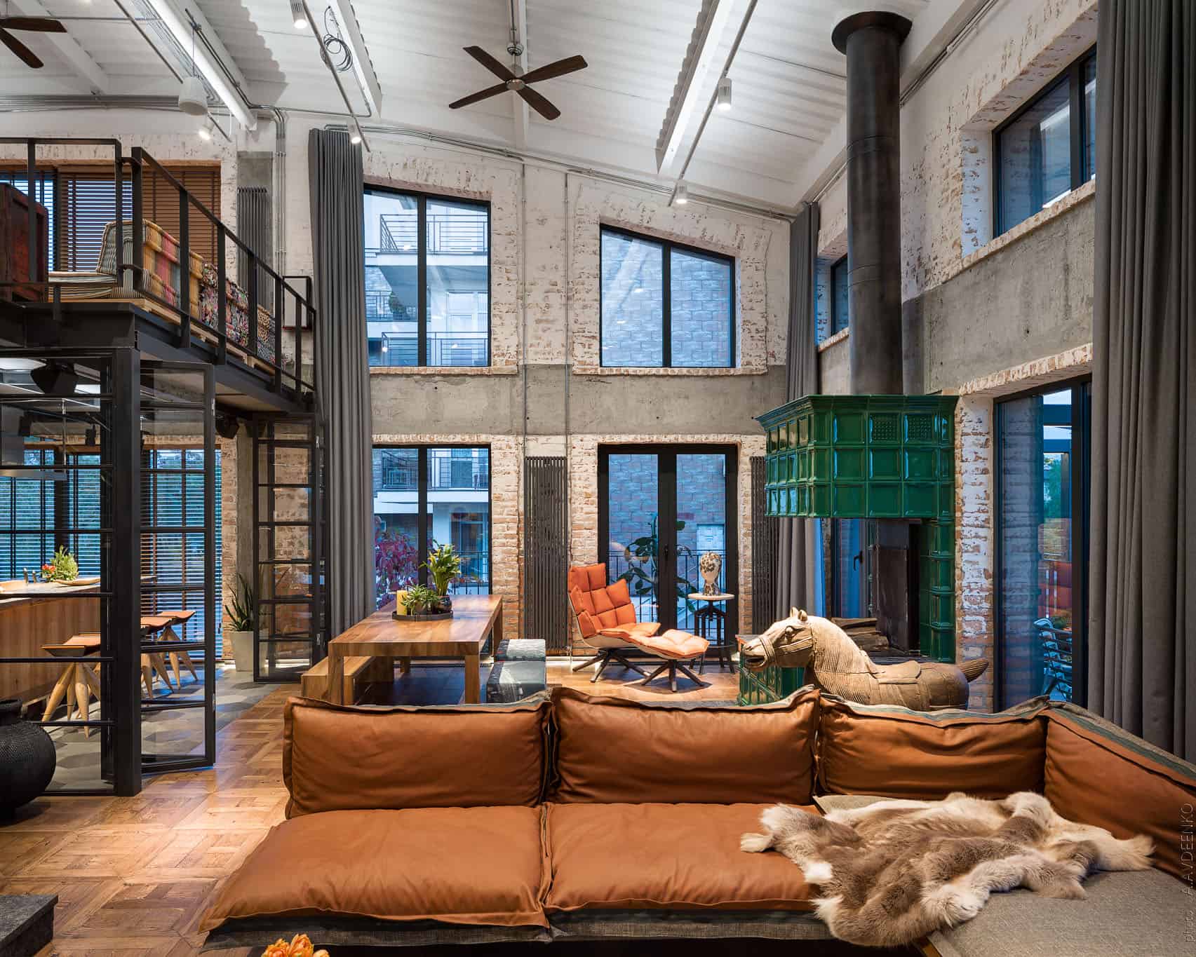 Industrial loft style living room with exposed brick walls, large windows, modern furniture, and vintage touches, showcasing contemporary architectural design and interior art.