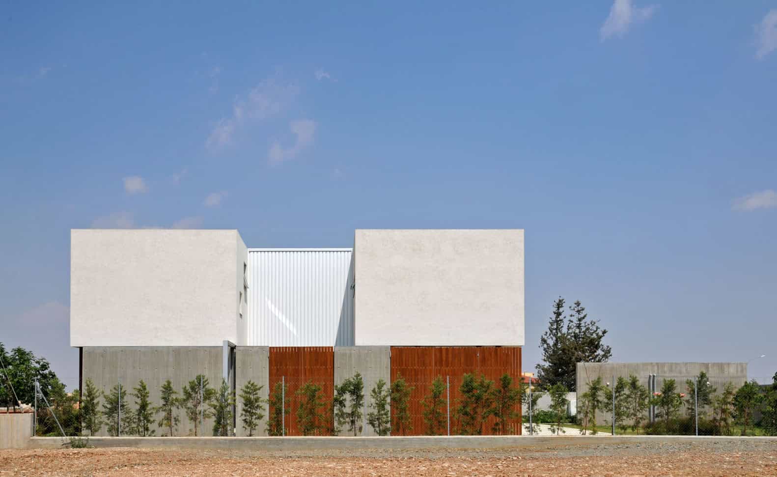 Modern minimalist white concrete residential building with clean lines and geometric design.