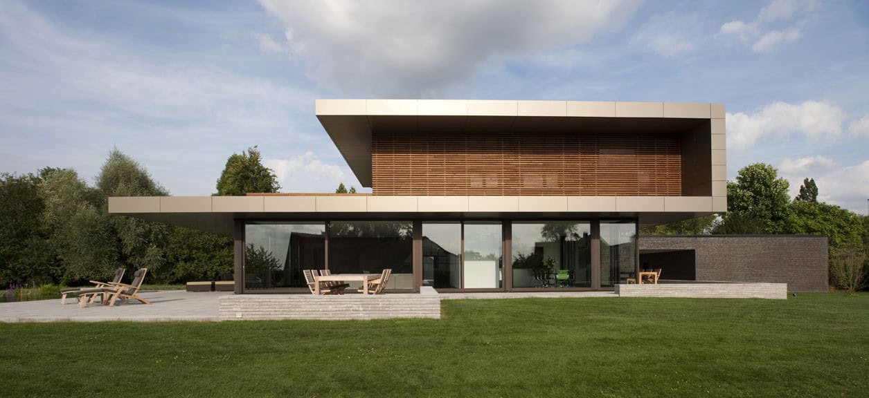 Modern contemporary house with large glass facade and wooden accents in suburban setting.