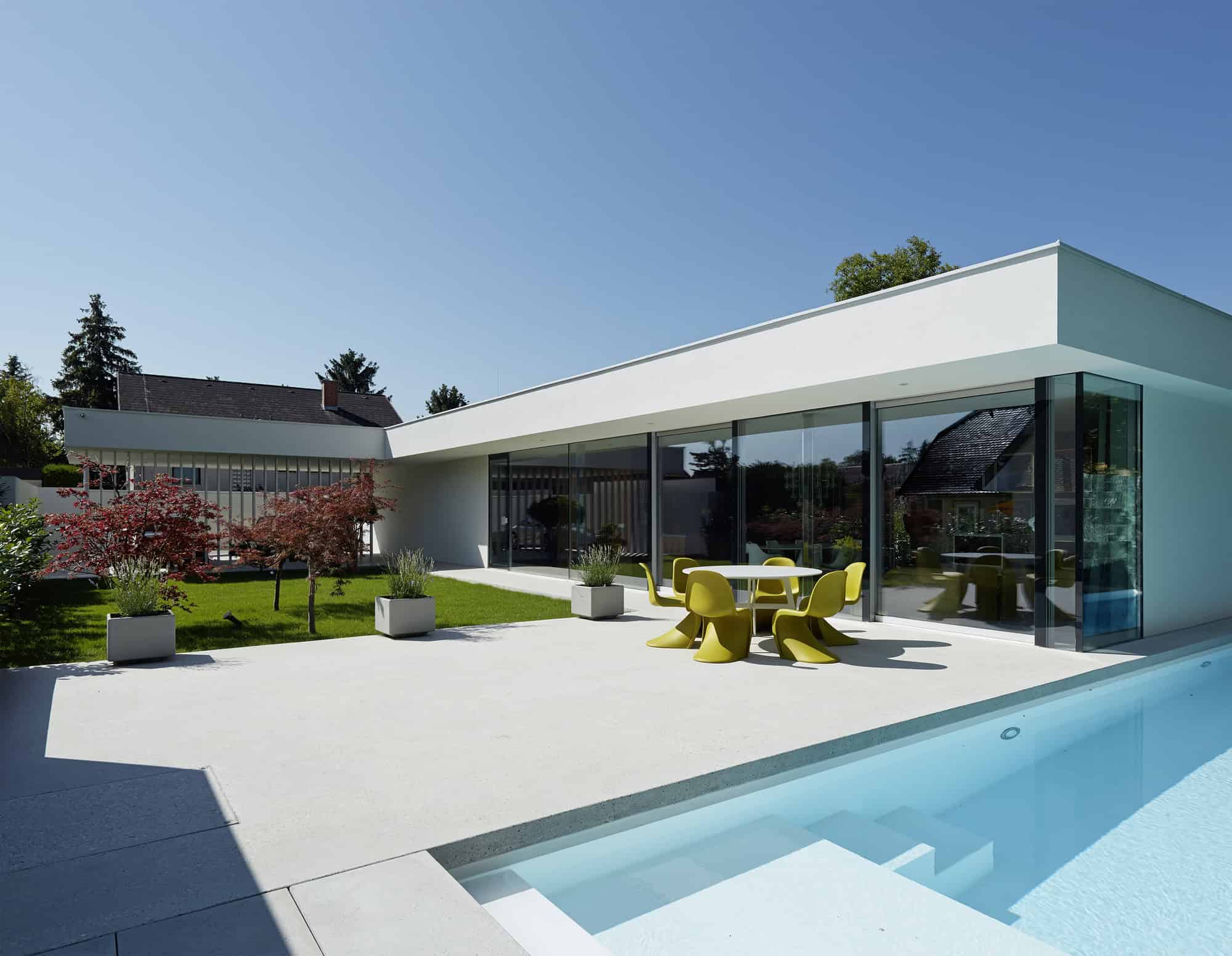 Modern minimalist house with sleek design, large glass windows, and outdoor pool, showcasing contemporary architecture and innovative home design.
