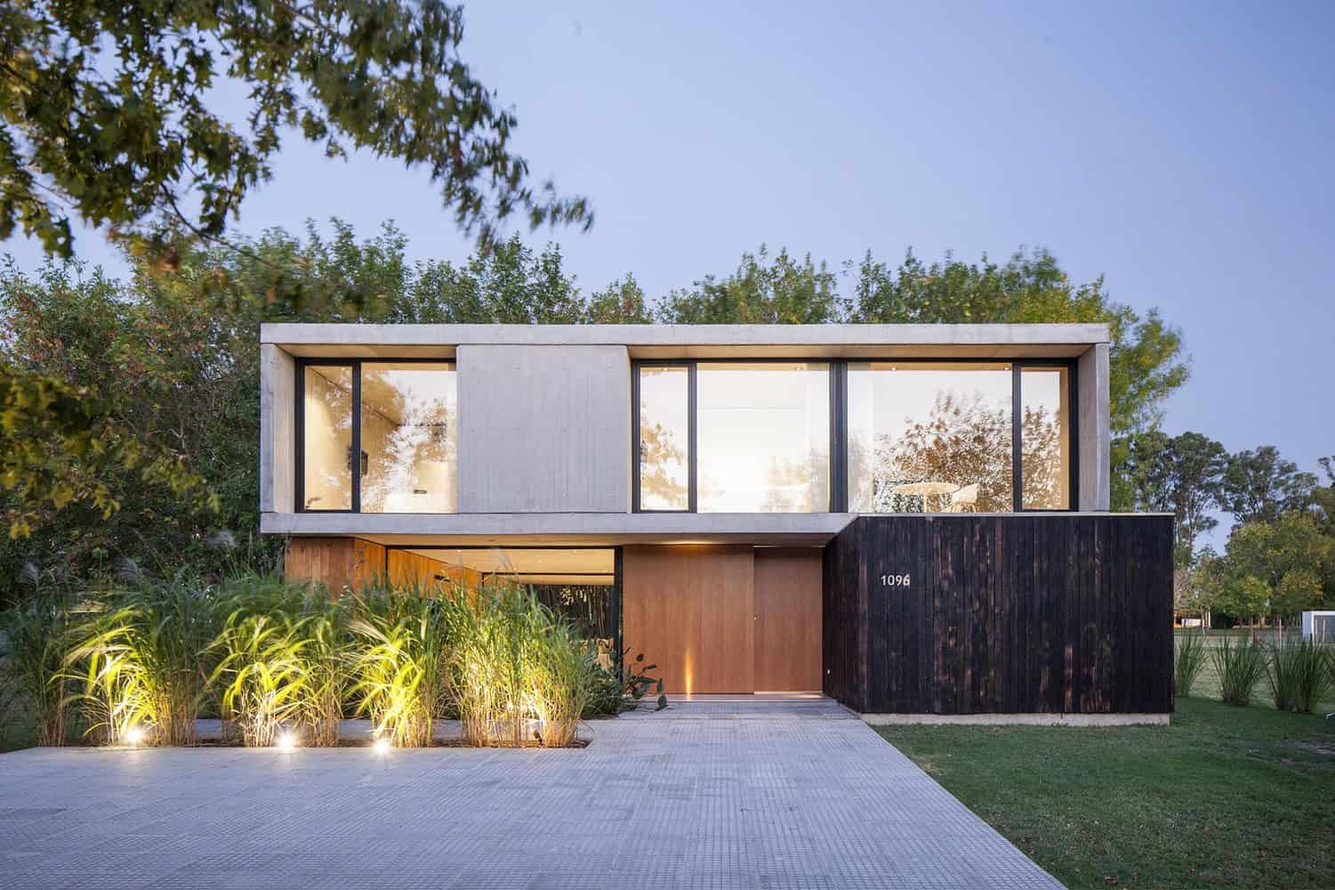 Modern minimalist house with clean lines and large glass windows, showcasing contemporary architectural design and landscaping.
