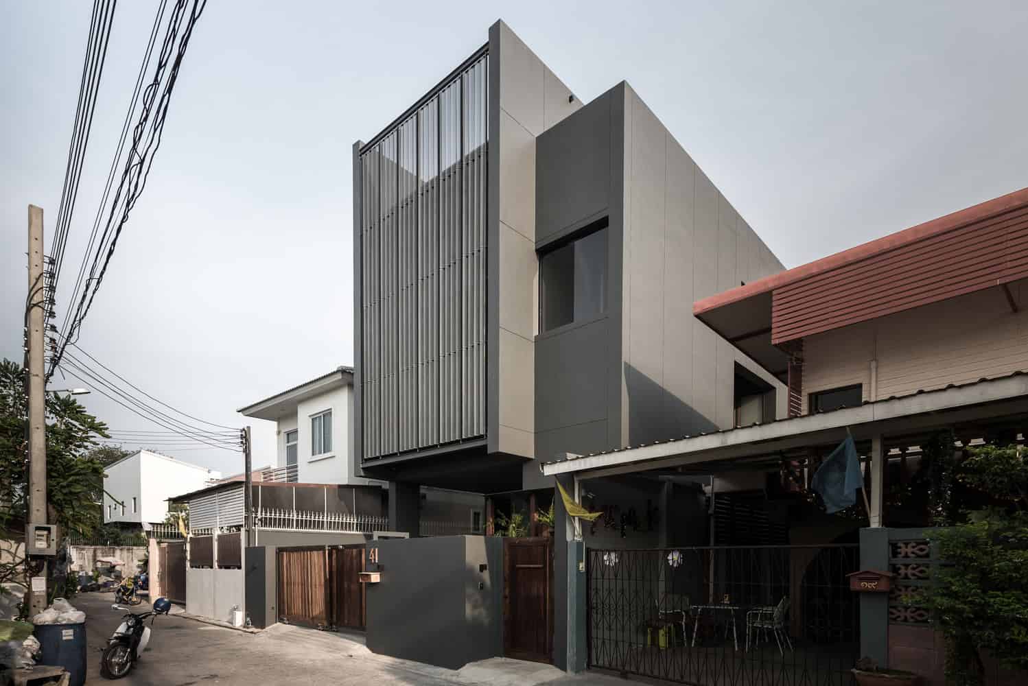 Contemporary modern house with sleek gray facade and vertical metal cladding, showcasing innovative architecture and urban residential design.