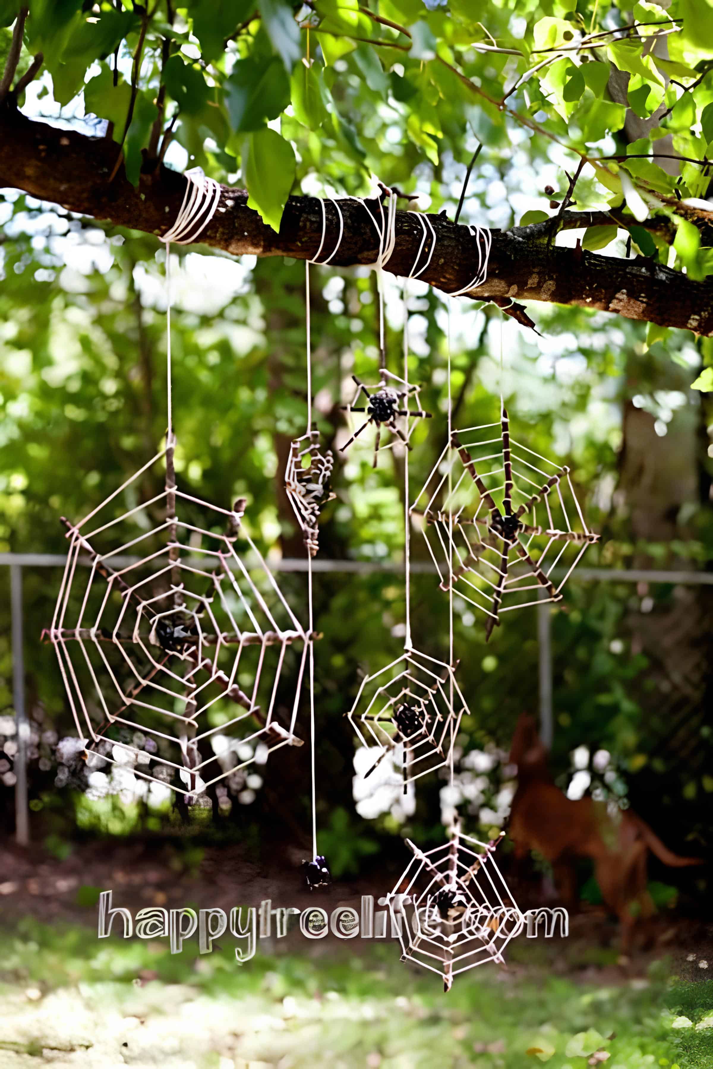 DIY yarn spider webs hanging on tree for outdoor Halloween decor
