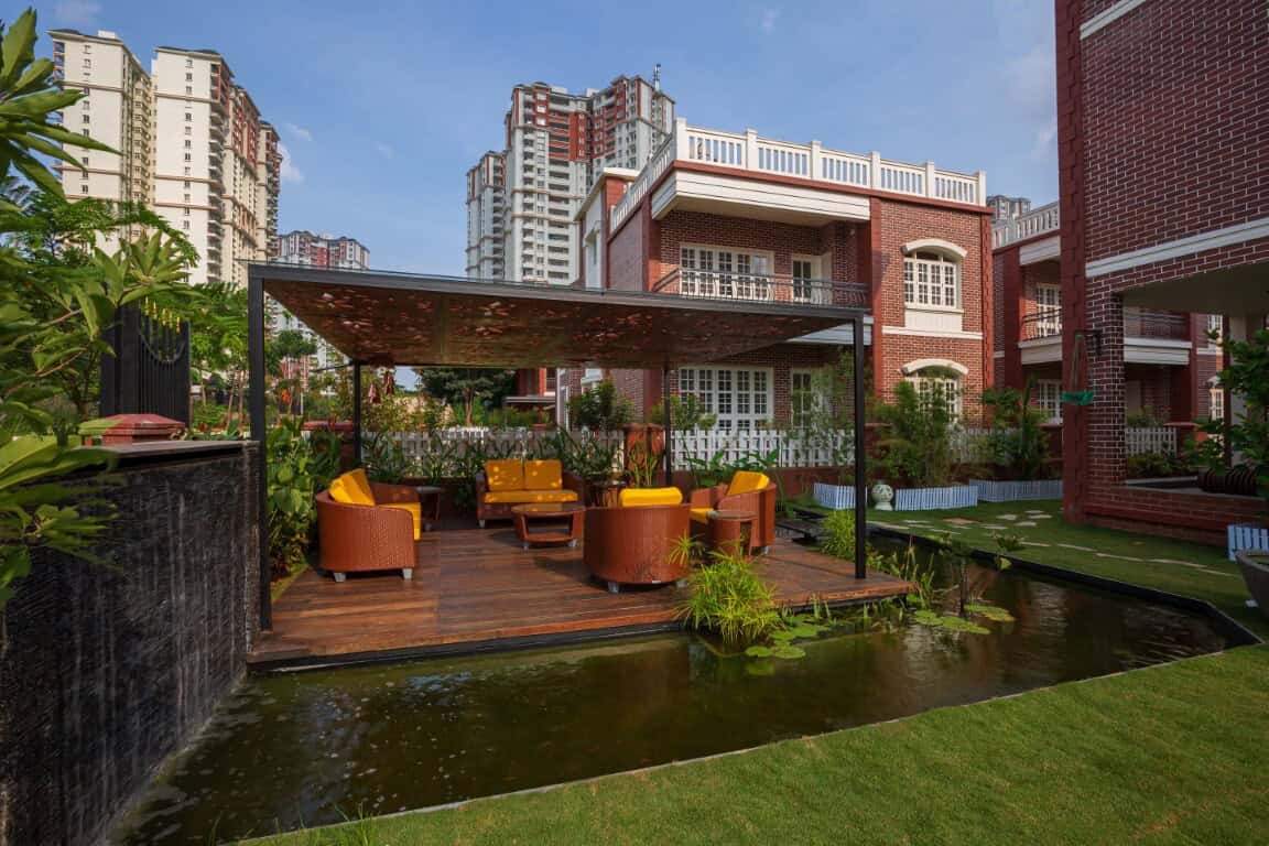 Modern outdoor seating area with water feature and urban residential backdrop, showcasing contemporary architecture and stylish yard design.