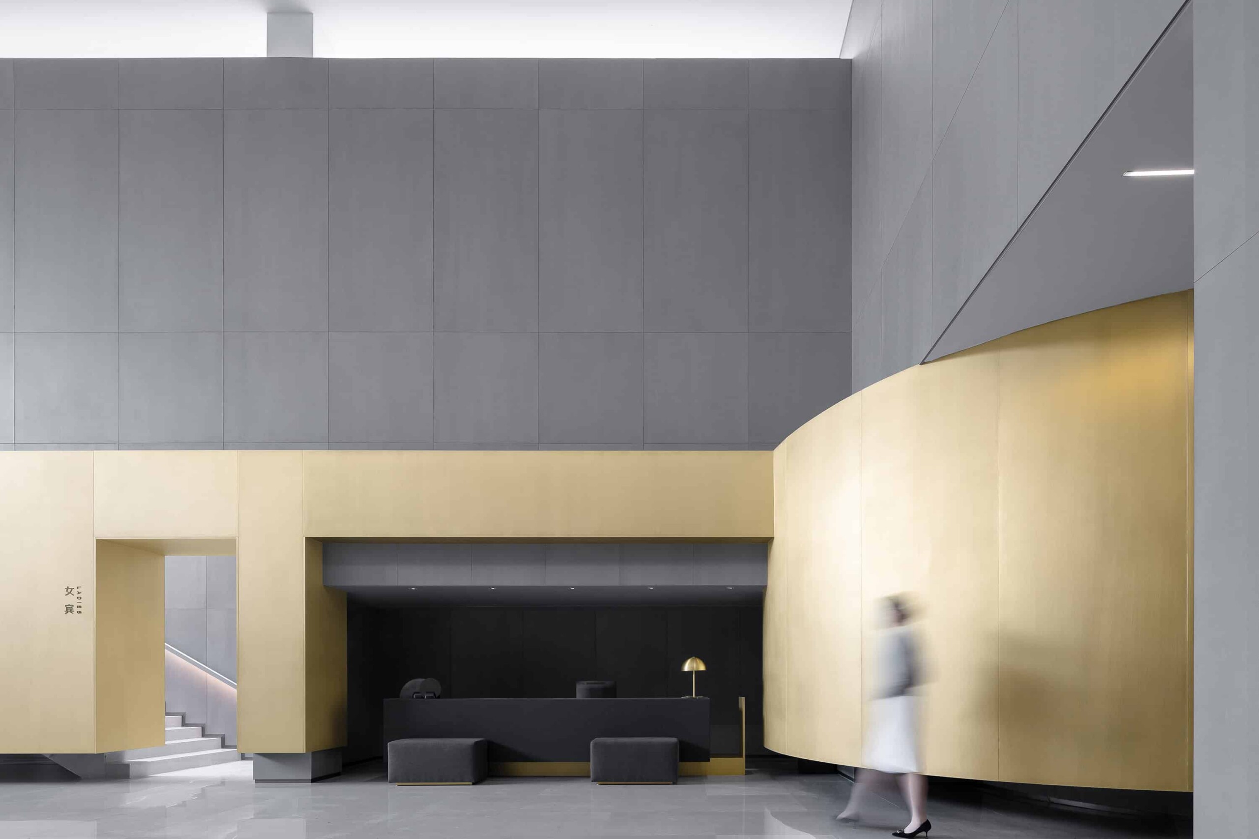 Modern architectural design with sleek grey and gold accents in a contemporary building interior featuring clean lines and minimalist style.