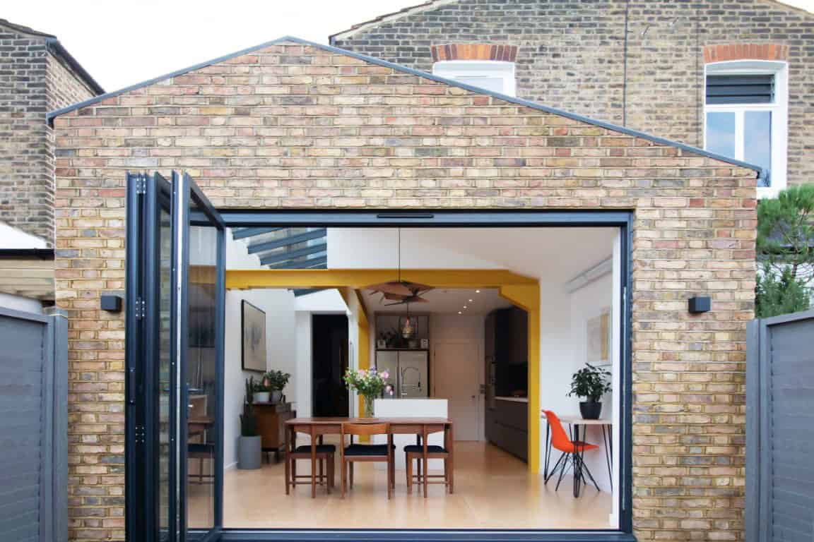 Modern brick extension with open folding glass doors showcasing contemporary interior design and indoor-outdoor living space.