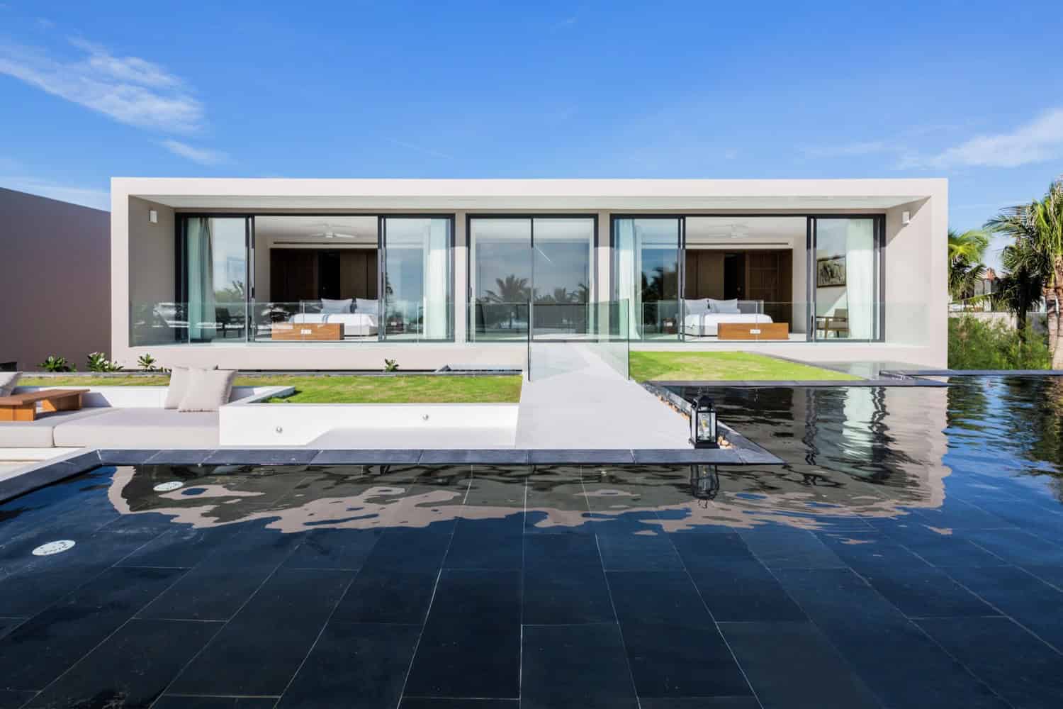 Modern luxury house with sleek design, large glass windows, and infinity pool, showcasing contemporary architecture and stylish outdoor living spaces.