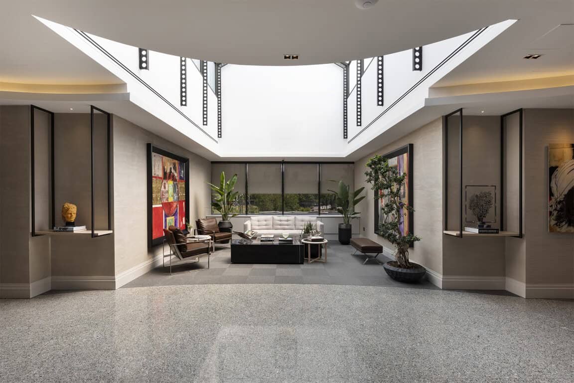 Modern hotel lobby interior with skylight and contemporary furniture.