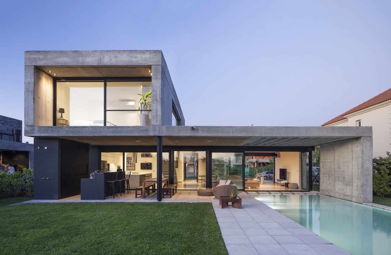 Modern minimalist concrete house with open-plan living, large glass windows, and an outdoor pool. Architectural design showcases sleek lines and contemporary industrial aesthetics.