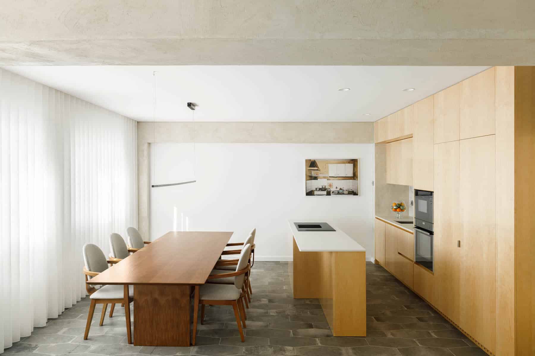 Sleek modern kitchen with minimalist design, wooden cabinetry, and a spacious dining area featuring a large wooden table and stylish chairs, perfect for contemporary home interiors.