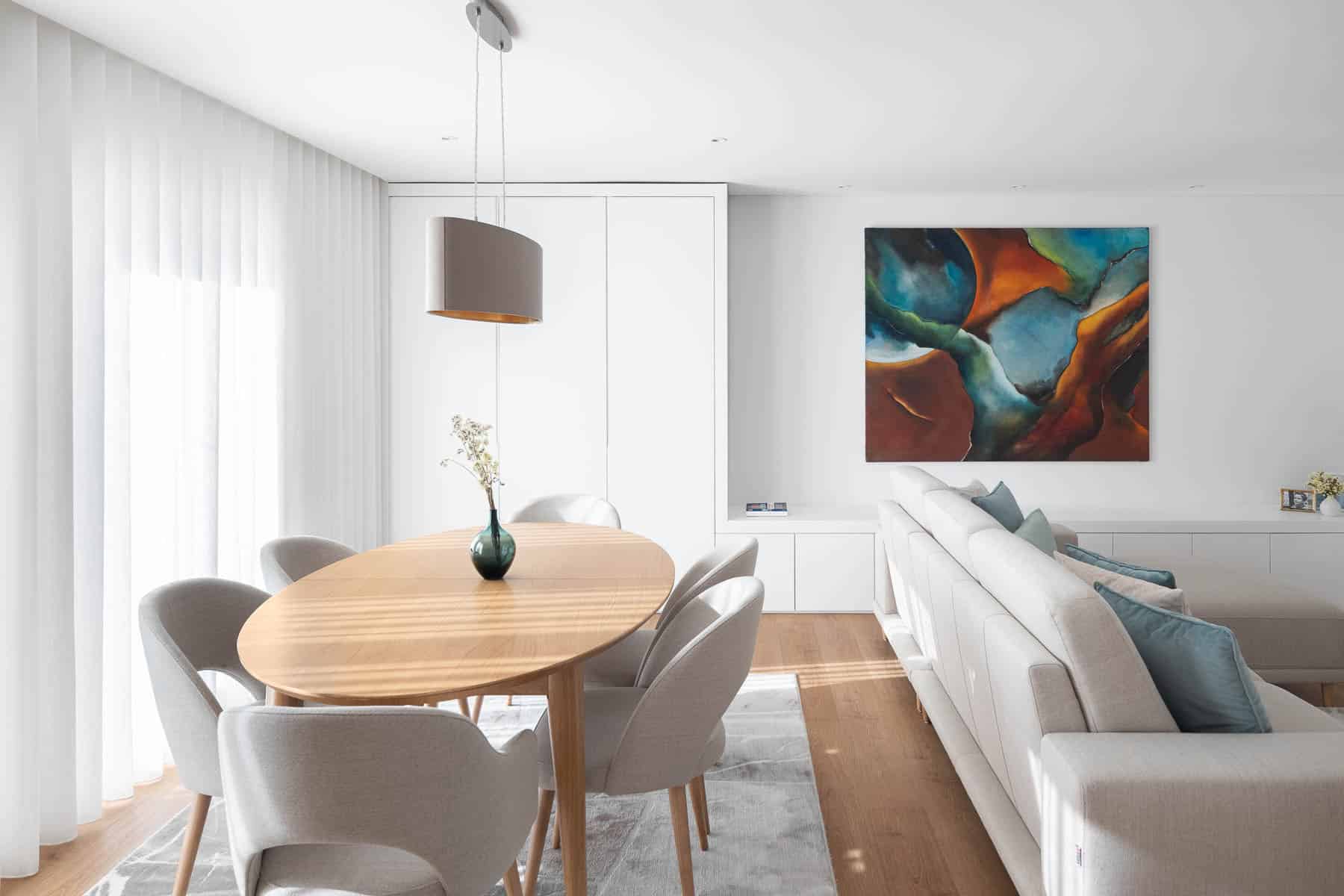 Modern minimalist dining and living room interior with abstract artwork and neutral color palette for contemporary architecture and interior design.