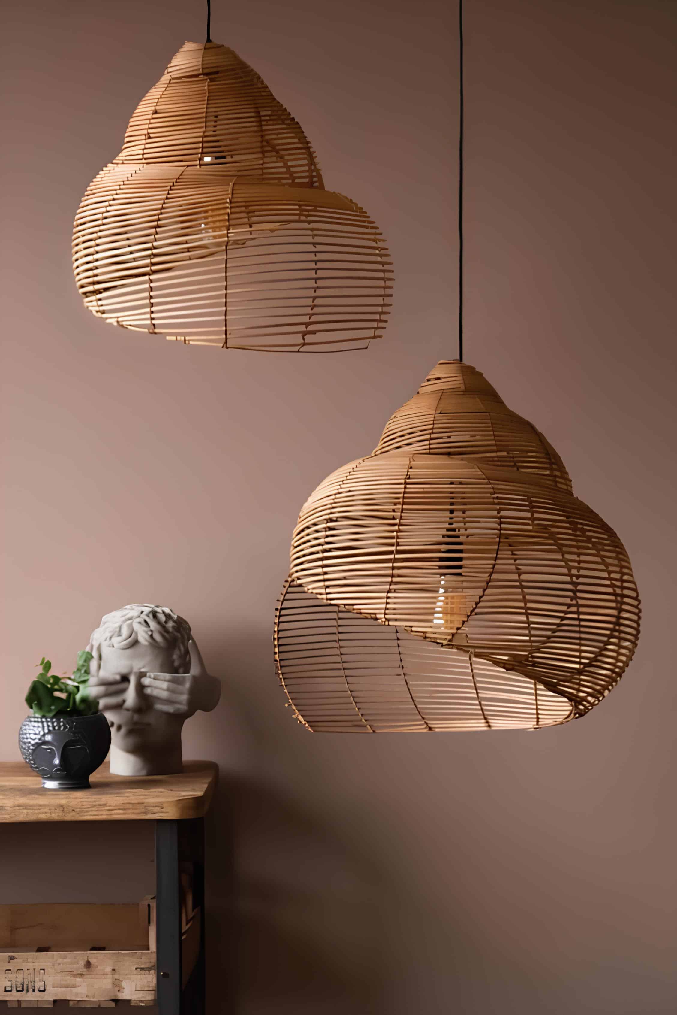 Abstract sculptural rattan pendant lights hanging against taupe wall with artistic decor