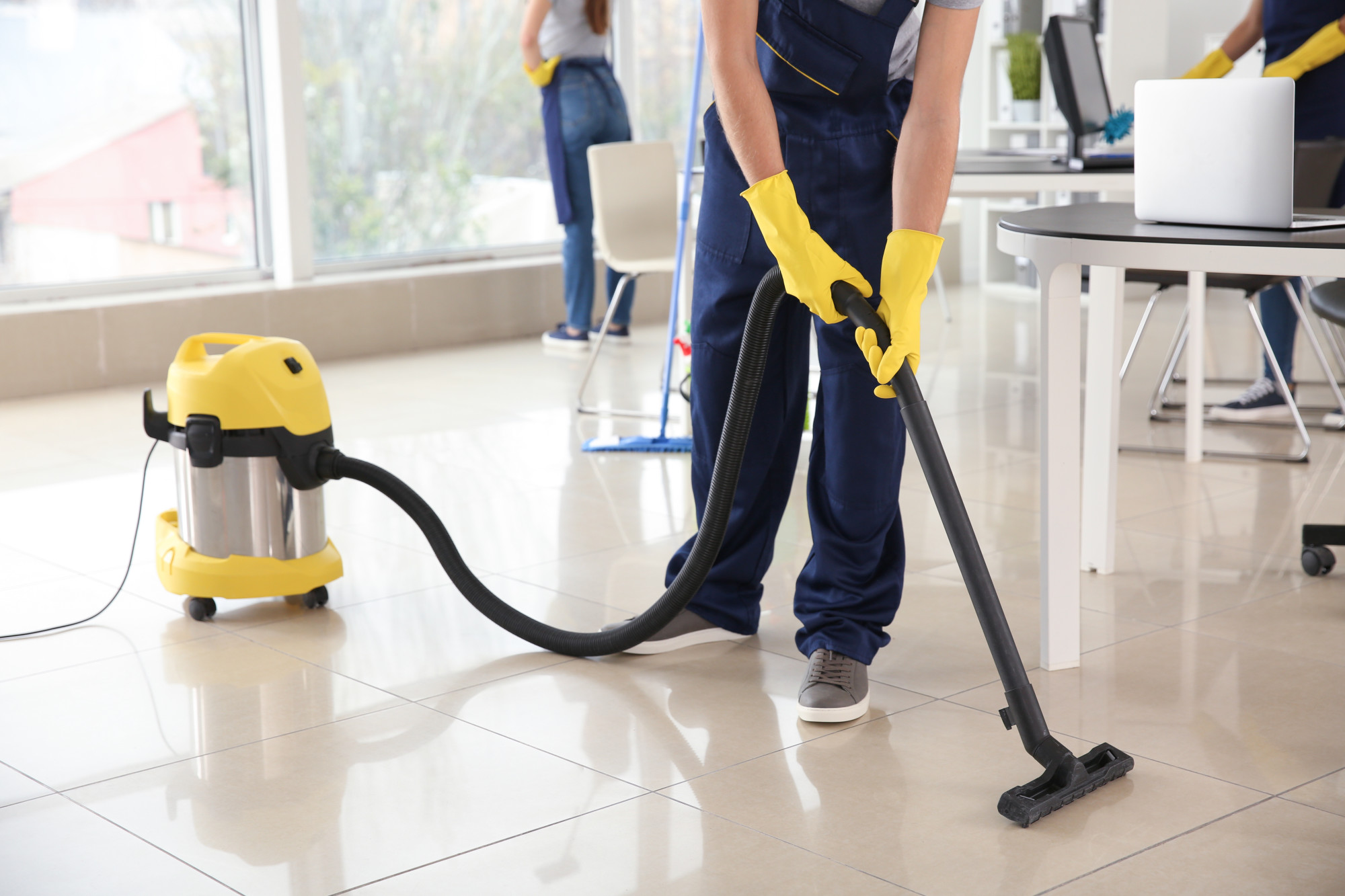professional cleaner vacuuming a tile floor