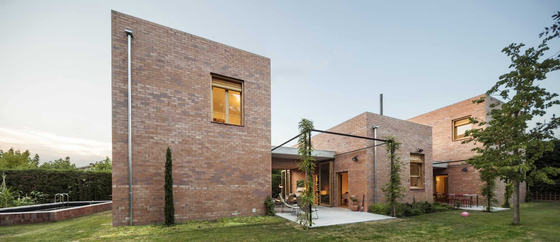 Contemporary brick house with modern architecture and lush backyard garden.
