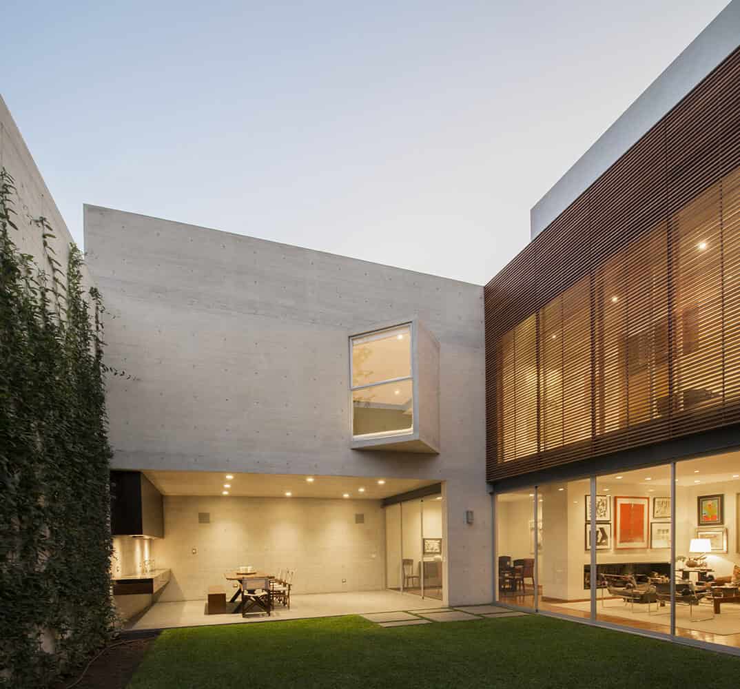 Contemporary modern house exterior featuring minimalist concrete walls, large glass windows, and wooden accents, showcasing innovative architectural design and stylish outdoor living space.