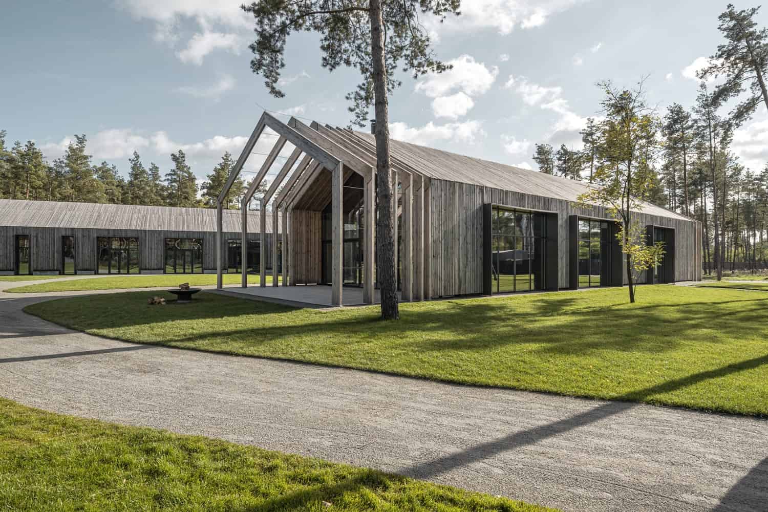 Modern wooden architecture with contemporary design elements in a lush green landscape.