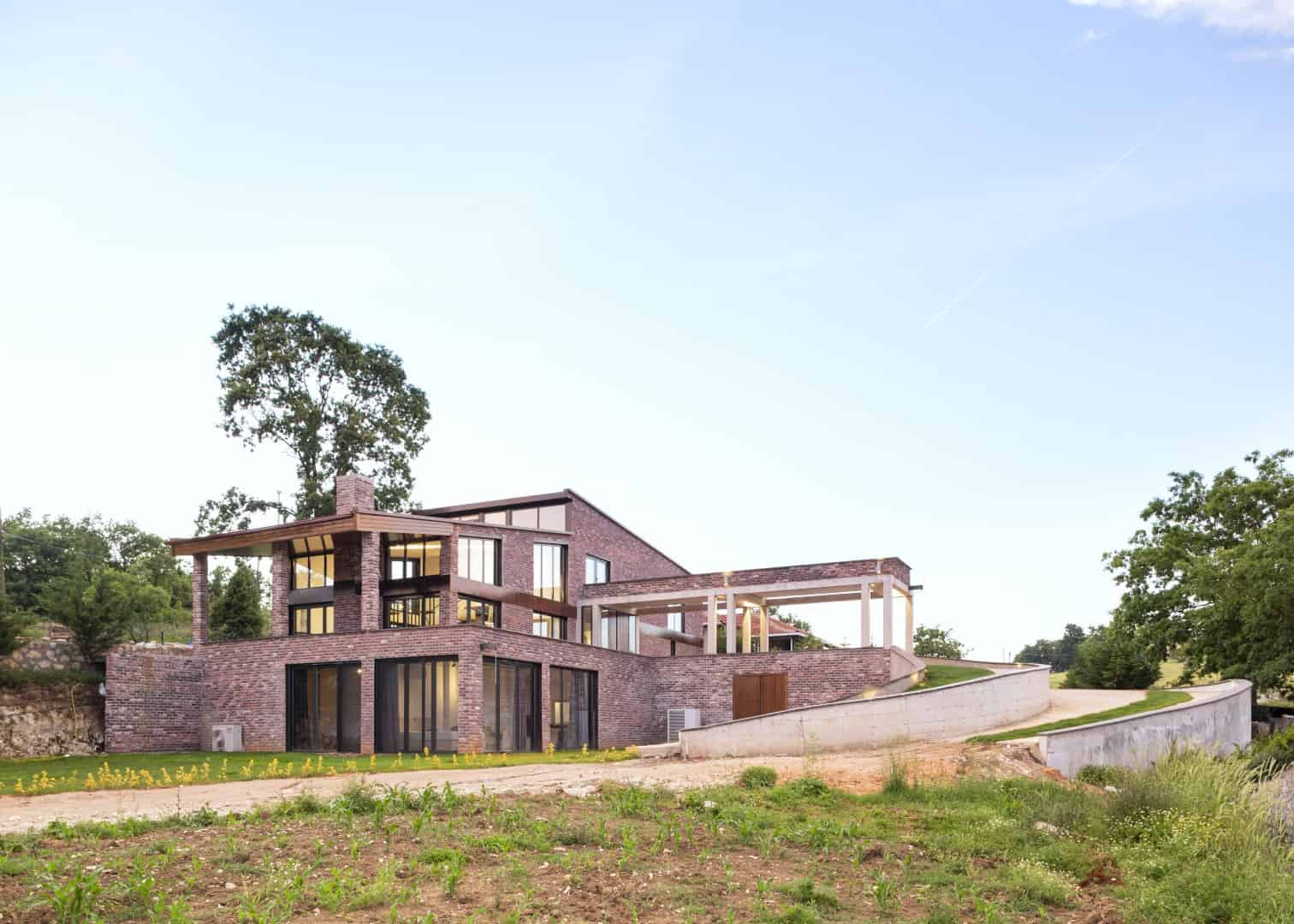 Modern wooden house with innovative curved architecture featuring contemporary design elements and outdoor seating area.