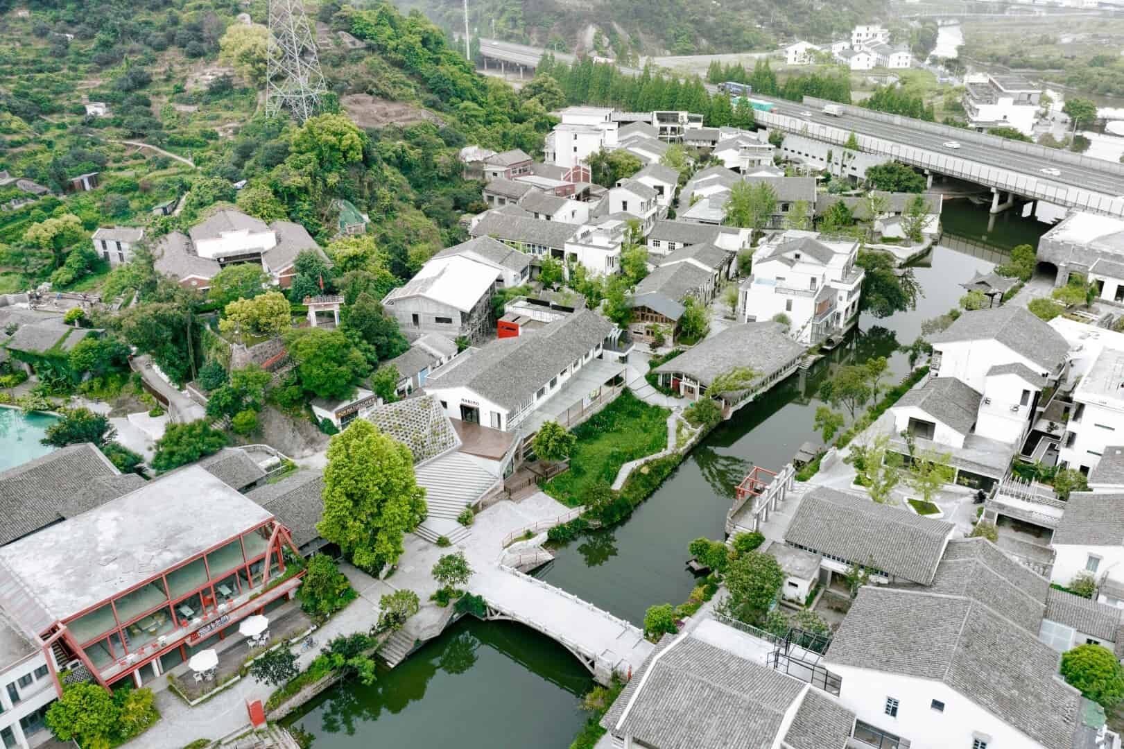 Serene riverside village with modern architecture, lush greenery, and scenic waterways showcasing contemporary residential design and harmonious integration with nature.