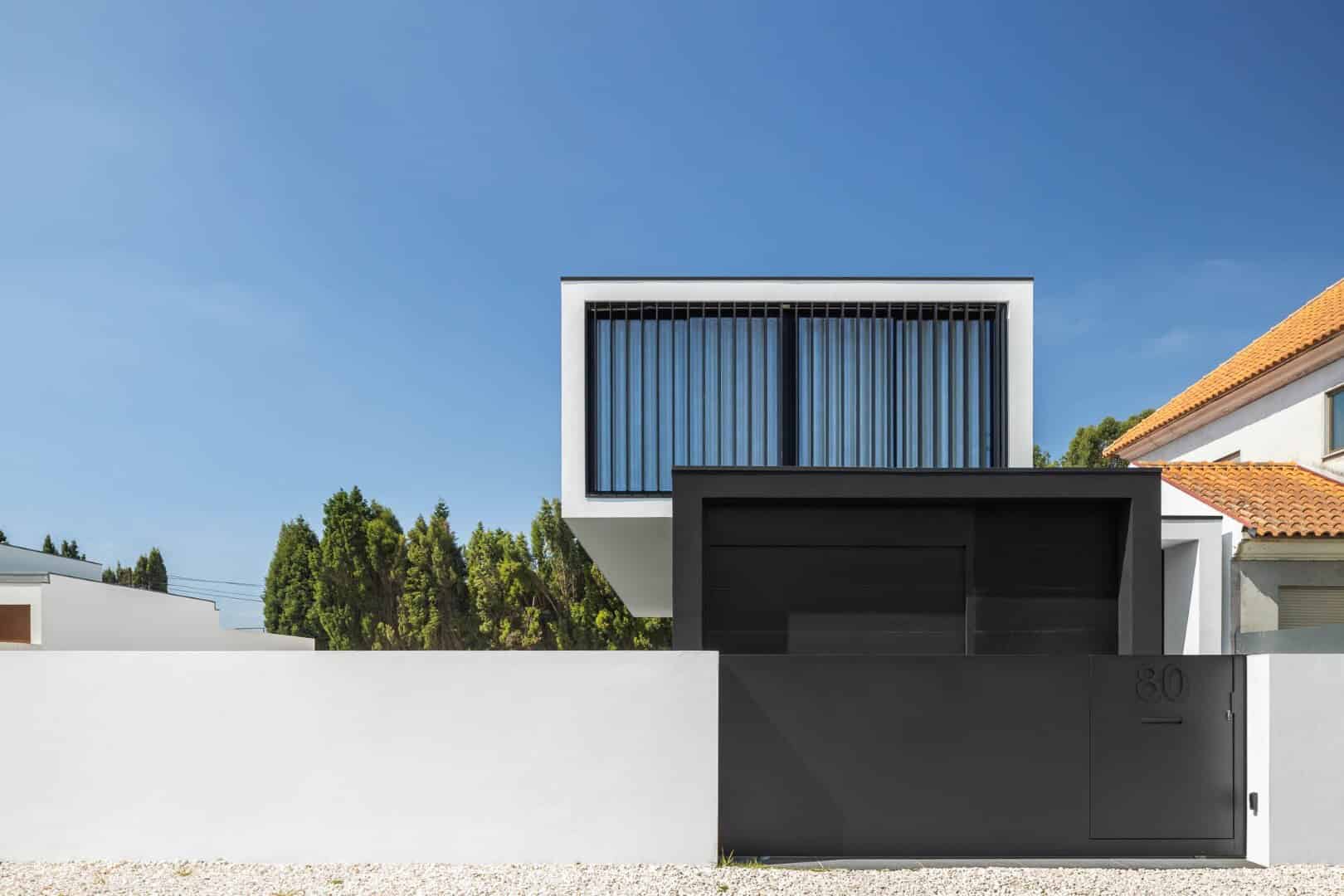 Contemporary modern house with minimalistic black and white facade, sleek architectural design, clean lines, and large windows, emphasizing modern architecture and stylish residential design.